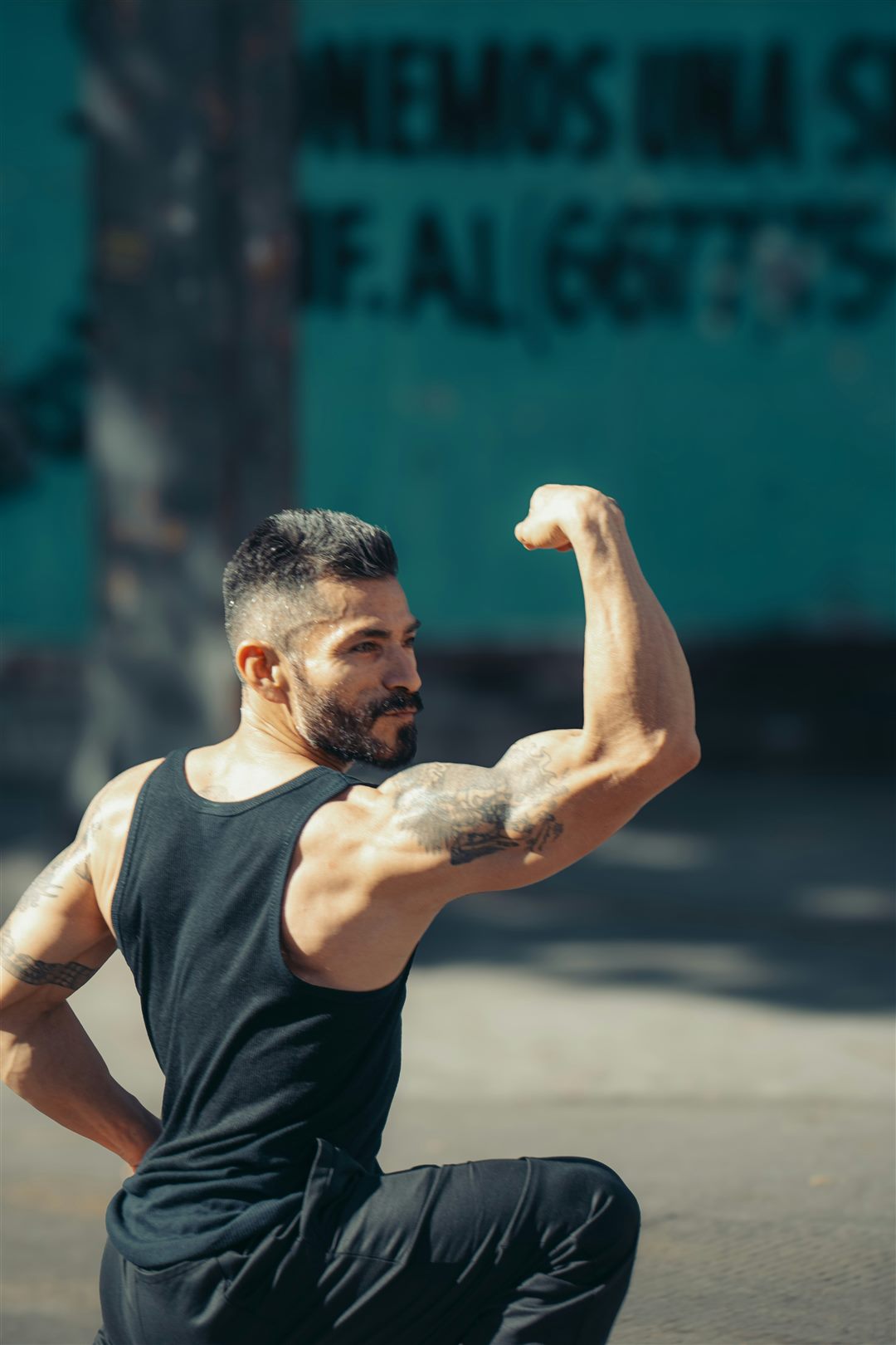 Hombre flexionando el bíceps al aire libre